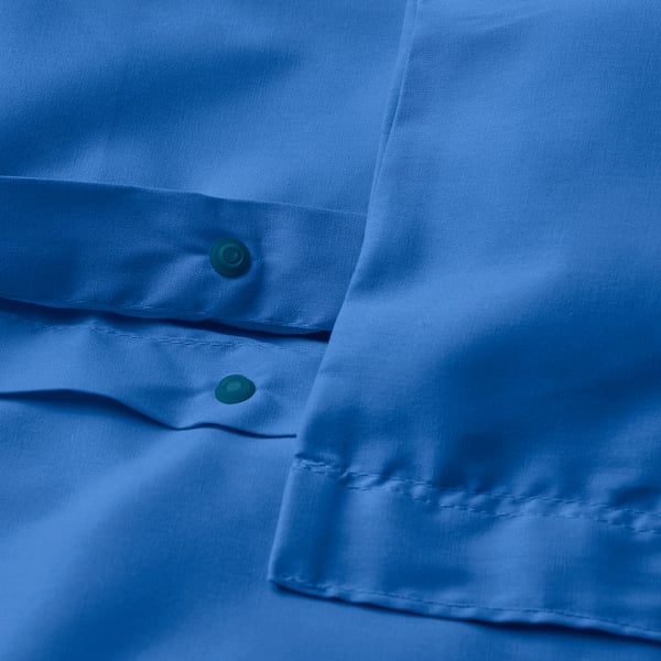 Gros plan de la housse de couette bleue avec fermeture à bouton-pression visible en bas.