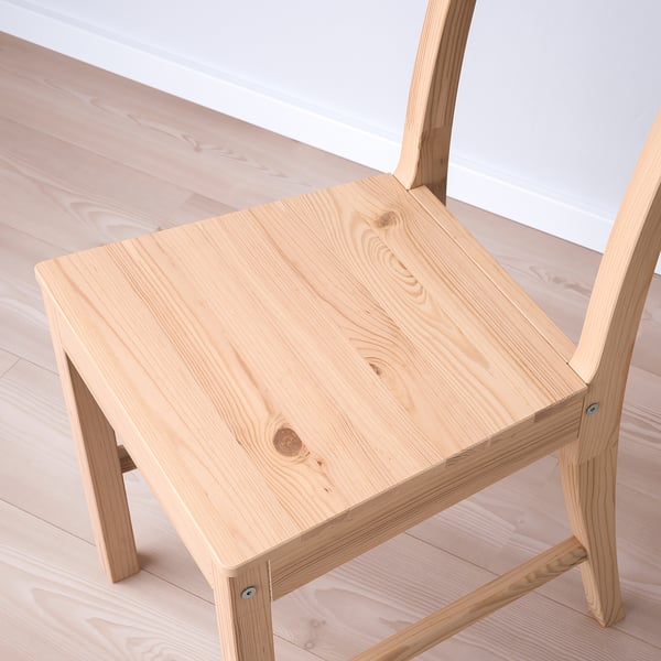 Chaise en bois minimaliste, finition légère, dossier incliné, design robuste.
