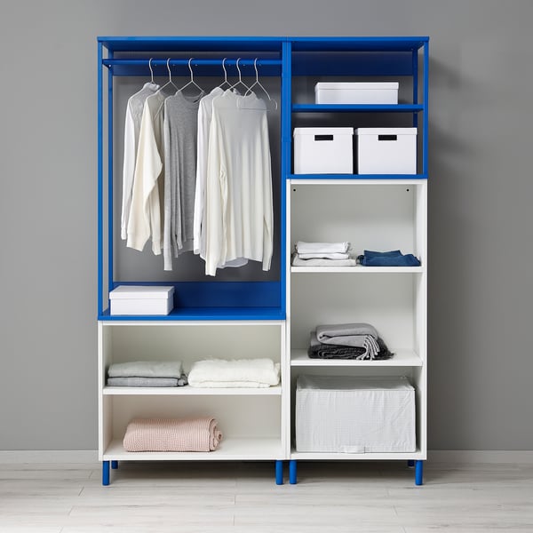 Unité de rangement PLATSA bleue et blanche avec vêtements et objets pliés, avec pieds réglables et étagères ouvertes.