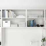 L’image montre des étagères de rangement modulaires PLATSA. Les étagères contiennent des livres et des papiers, démontrant une solution de rangement polyvalente.