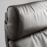 Coin du fauteuil en cuir foncé, présentant un rembourrage doux et de haute qualité et des coutures fines.