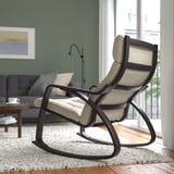 Fauteuil à bascule confortable aux lignes courbes et siège rembourré dans le salon, offrant détente et soutien de la nuque.