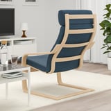 Fauteuil bleu avec cadre en bois, assise et dossier rembourrés, placé près d’une petite table.