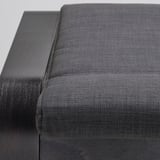 Représente un gros plan d’un repose-pieds POÄNG confortable de couleur sombre avec un cadre en bois robuste et un siège rembourré de haute qualité.