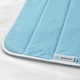 Gros plan du coussin de refroidissement ikea REXBEGONIA, bleu clair avec bordure blanche, présentant une texture douce et des coutures de qualité.