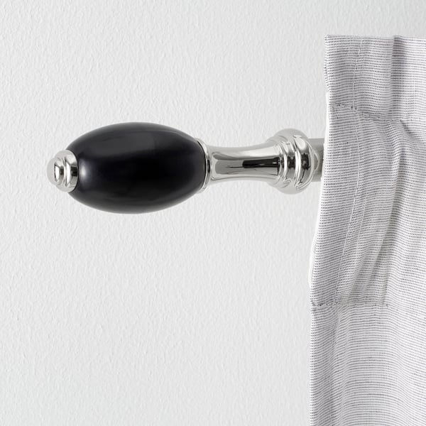 Support de tringle à rideau noir et argent avec finition brillante sur le mur tenant le rideau rayé.