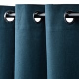 Les rideaux bleu foncé avec œillets pendent en douceur, bloquant la lumière et assurant l’intimité.