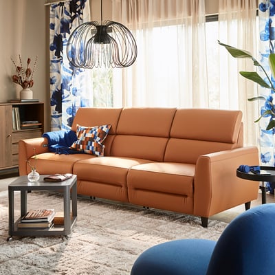 Canapé RULLERUM orange dans le salon, dossier haut, accents bleus, point focal.