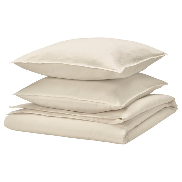 Parure de lit beige pliée. Comprend une couette et des taies d’oreiller. Doux, prélavé avec un design froissé chic.