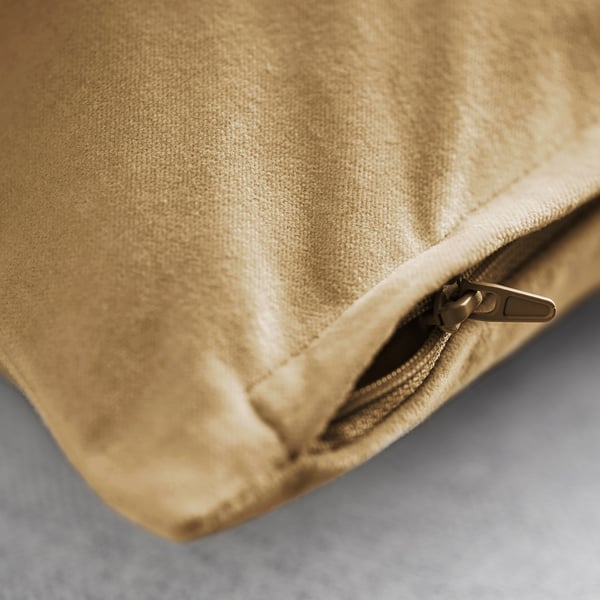 Gros plan de la fermeture éclair de la housse de coussin dorée en peluche, mettant en valeur la texture douce du velours de coton.