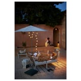 Patio extérieur avec meubles SEGERÖN, canapé, table, lampe et parasols.