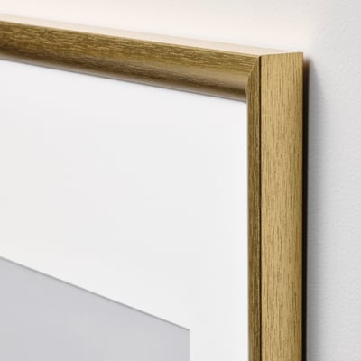 Miroir à cadre doré avec bord texturé, monté sur un mur.