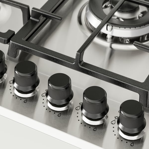 Cuisinière à gaz avec quatre boutons à l’avant, brûleurs sur le dessus, finition métallique.