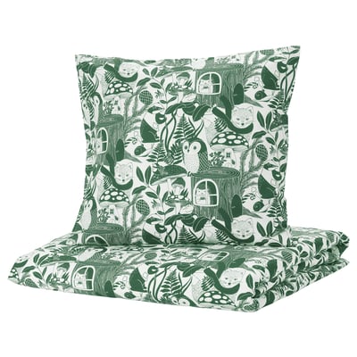Cette image montre une housse de couette et une taie d’oreiller vertes et blanches sur le thème de SKOGSDUVA, avec des créatures de la forêt et des souches d’arbres.