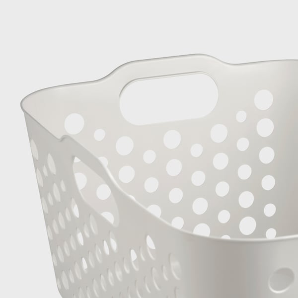 Panier à linge en plastique perforé blanc avec poignées arrondies, robuste et ventilé.