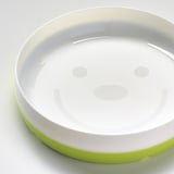 Assiette SMÅGLI kids : plastique pctg durable, vert et blanc, base antidérapante, design de visage joyeux.