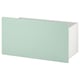 Rangement en forme de boîte vert clair avec côtés blancs, design moderne et minimaliste, sur roulettes pour un déplacement facile.