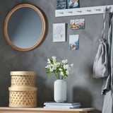 Un élégant panier SNÖPLOG en peuplier naturel tissé de couleur beige, qui s’adapte parfaitement à une étagère et contient des affaires.