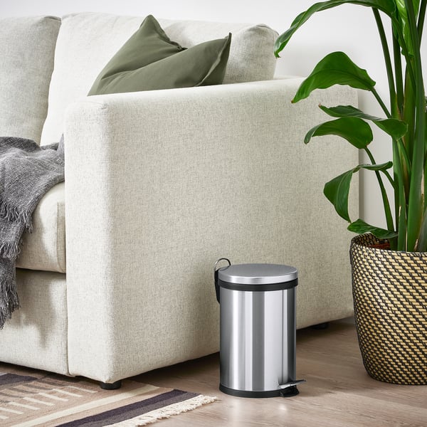Petite corbeille SNÖRPA argentée à côté d’un canapé blanc. Idéal pour les espaces restreints.