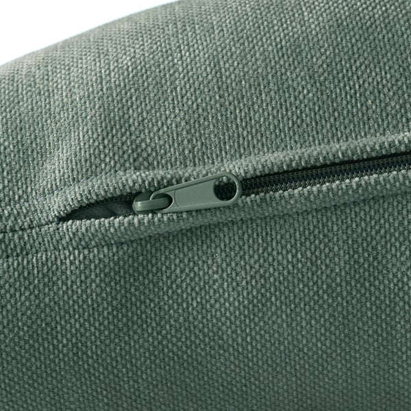 Gros plan d’une fermeture éclair de haute qualité sur un coussin en tissu texturé moelleux. Le curseur de la fermeture éclair est lisse et durable, assurant une utilisation durable.