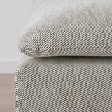 Gros plan d’un canapé en tissu patterson doux et texturé, mettant en valeur sa qualité confortable et accueillante.