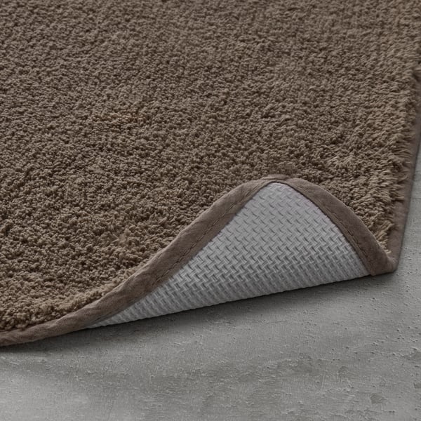 Tapis de bain : le coton épais absorbe l’eau, le support en latex ajoute de l’adhérence.