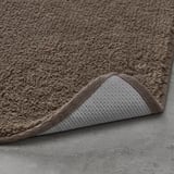 Tapis de bain : le coton épais absorbe l’eau, le support en latex ajoute de l’adhérence.