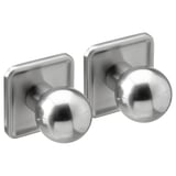 Deux boutons ronds en acier inoxydable sur des plaques carrées, design rétro moderne.
