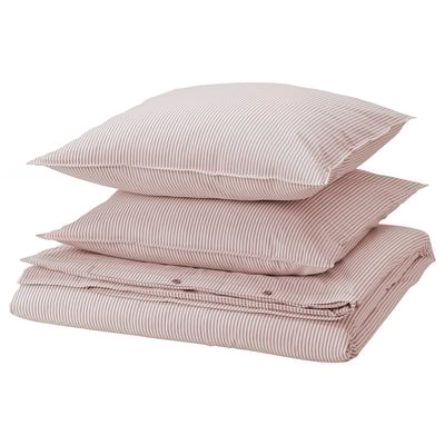 Pile d’oreillers rayés rouges et blancs, drap plié, coton, design minimaliste.