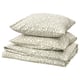 Une pile de quatre coussins SORGMANTEL en vert clair avec des motifs de feuilles. Ils sont de forme carrée et fabriqués en polyester et coton recyclés.