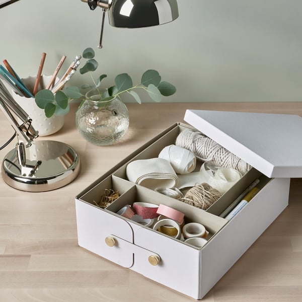 Boîte d’artisanat organisée sur le bureau avec des bobines, du ruban adhésif et des outils. Comprend des compartiments amovibles pour les petits objets.