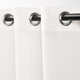 Des rideaux blancs transparents sont suspendus avec des œillets chromés, filtrant la lumière, offrant de l’intimité.