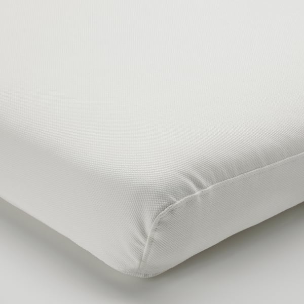 Coussin blanc avec coutures soignées et tissu lisse.