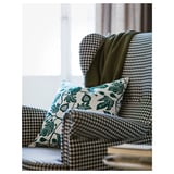 Fauteuil confortable à motif pied-de-poule avec des coussins moelleux, qui respire la qualité et le confort.