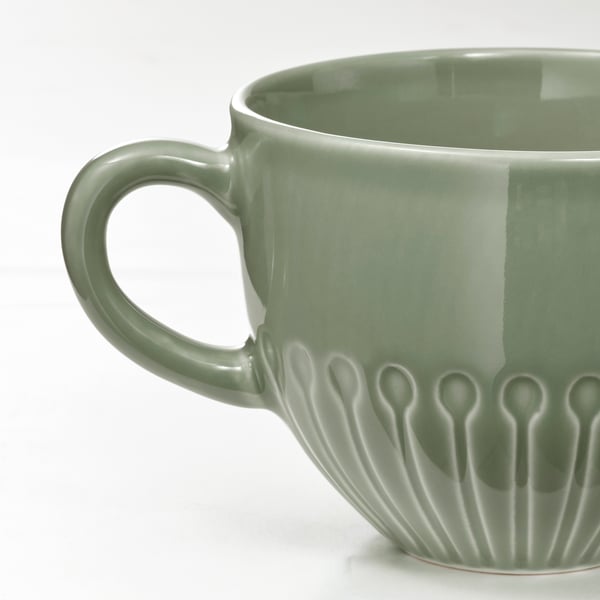 Mug floral vert avec poignée robuste.