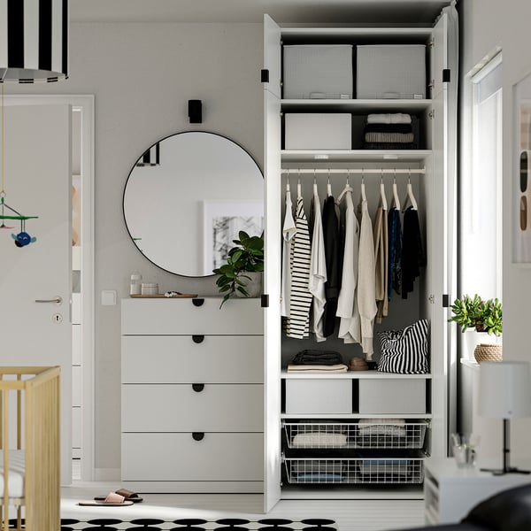 Placard organisé avec des cartons STUK contenant vêtements et accessoires. La garde-robe comprend des étagères et un espace suspendu, maintenant l’ordre et l’accès facile.