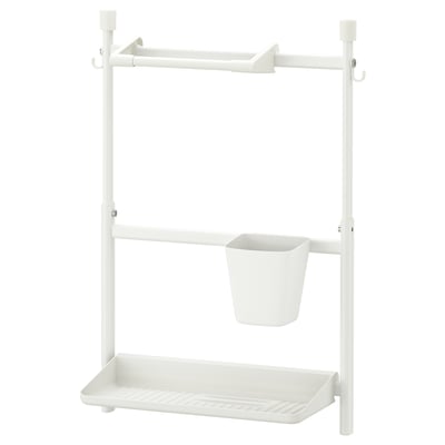 Un support de rangement SUNNERSTA blanc avec des crochets, un panier suspendu et une étagère.