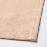 Serviette en coton beige, soigneusement pliée, mettant en valeur le tissage et les coutures fins, mettant en valeur la qualité.