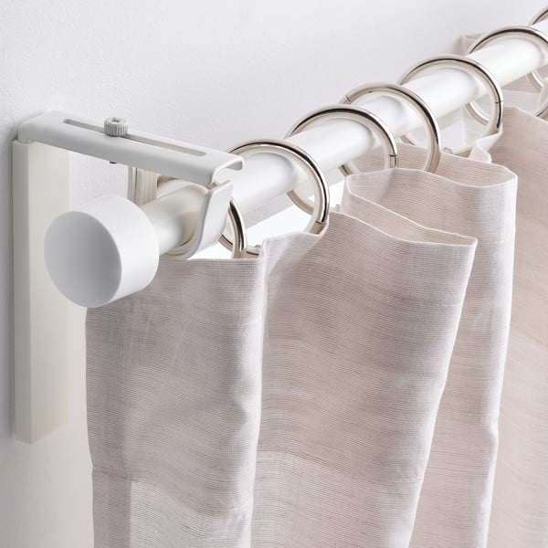 Les rideaux immatériels sont suspendus à une tige métallique avec plusieurs anneaux, clips et crochets pour un glissement facile.