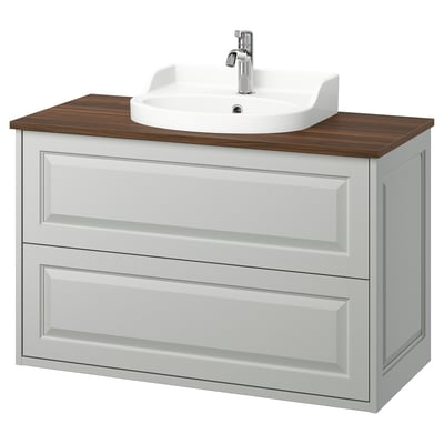 Le lavabo TÄNNFORSEN en gris clair avec plan de travail en bois et évier en céramique blanche, doté de deux tiroirs et de bords biseautés pour un look artisanal.