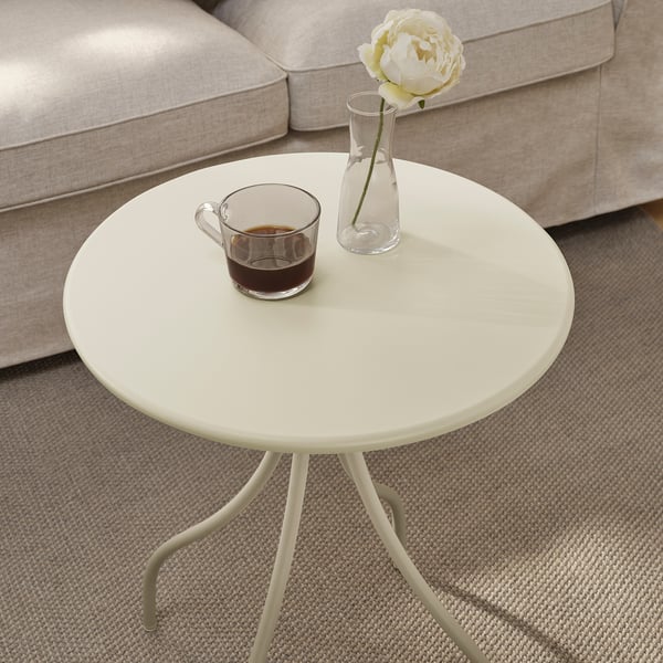 Petite table d’appoint ronde près du canapé avec tasse à café et vase à fleurs. Léger et facile à déplacer.