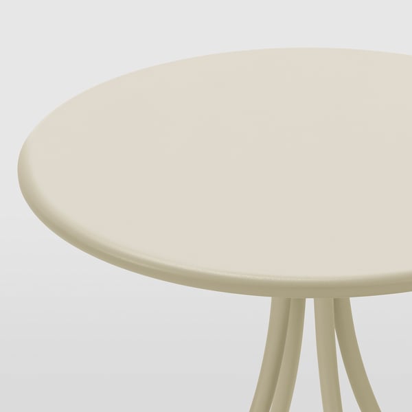 Table d’appoint ronde beige avec trois pieds, surface lisse et robuste.