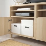 Armoire en bois clair avec deux boîtes de rangement blanches, idéale pour organiser les papiers et les petits objets.