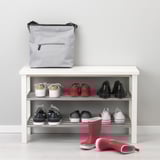 Organisateur d’entrée avec étagère à chaussures, contenant environ 6 paires, bottes de pluie rouges sur le sol, sac gris sur le dessus.