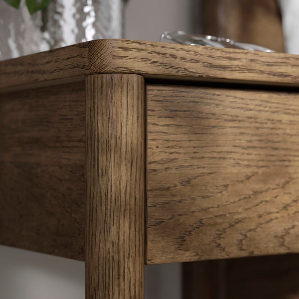 Table de chevet en bois aux bords arrondis et finition lisse.