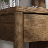 Table de chevet en bois aux bords arrondis et finition lisse.