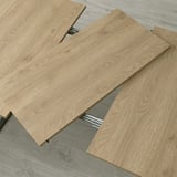 Panneaux de bois disposés pour transformer la table, montrant une capacité extensible pour s’asseoir.