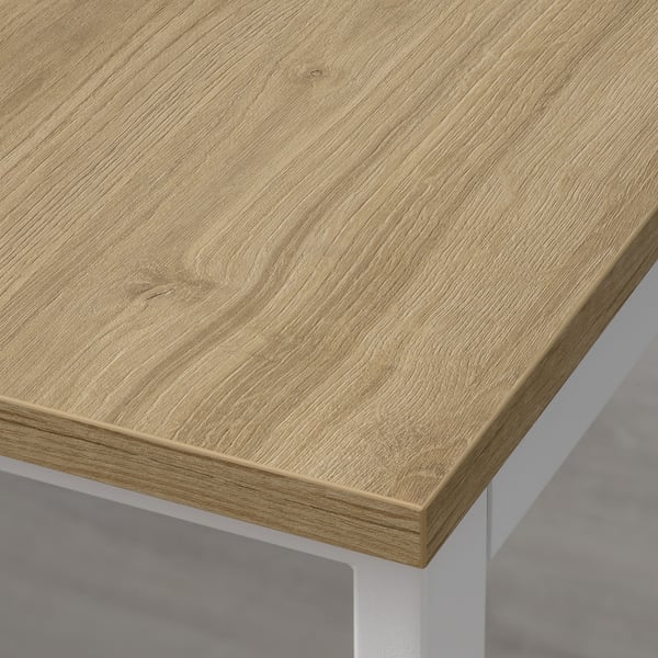 Gros plan d’un dessus de table en bois bien fini avec des bords lisses et une texture de grain naturel.
