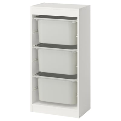 Une unité de rangement TROFAST blanche avec trois bacs gris amovibles pour organiser les articles.