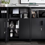 Unité de rangement en métal noir avec étagères ouvertes contenant des fournitures de bureau, une imprimante et une armoire fermée avec des clés.
